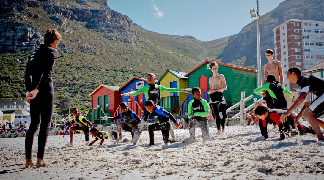 Volunteer getting children ready for surfing in South Africa Stretching on the beach in a surfing project, South Africa